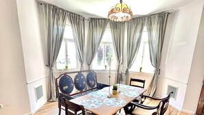A dining area with a round wooden table, six chairs, and a chandelier. - Old villa in the heart of Lorsch (Lorsch)