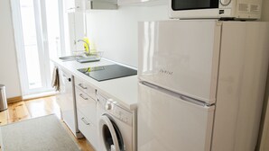 Una cocina moderna equipada con lavadora, microondas y refrigerador.