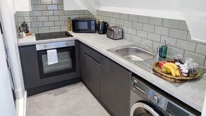 Una cocina moderna equipada con lavavajillas, horno, microondas, tostadora y pileta.