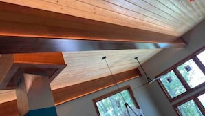 A room with a sloped ceiling, wooden beams, and large windows offering a view of the outdoors. - Wild Thing - Blowing Rock, Hot Tub, Big Views, NEW (Lenoir)