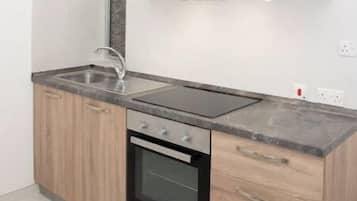 Een koelkast, kookgerei, borden en bestek