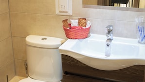 A bathroom with a white toilet, a sink with a mirror above it, and a wooden cabinet below. - Comfort Studio Apartment Combined Living, Bedroom and Kitchen as seen in photo (San Pawl il-Bahar)