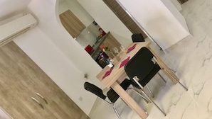 A dining area with a wooden table, black chairs, and a marble floor. - Comfort Studio Apartment Combined Living, Bedroom and Kitchen as seen in photo (San Pawl il-Bahar)