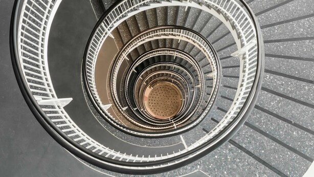Un escalier en colimaçon à plusieurs niveaux, avec un espace central ouvert.