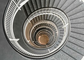 Un escalier en colimaçon à plusieurs niveaux, avec un espace central ouvert.