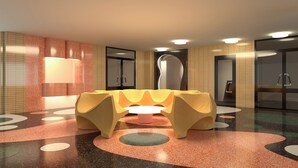 Une salle de bain moderne dotée d’un espace détente original, d’un grand miroir et d’un sol à motifs.