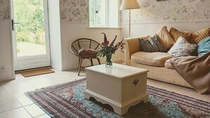 A living room with a sofa, a coffee table, a chair, and a lamp.