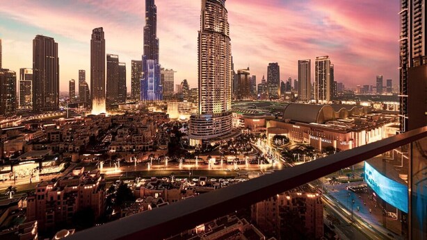 A cityscape with high-rise buildings, including a prominent skyscraper, and a well-lit urban area with roads and a bridge. - New 2B | Burj Khalifa | Dubai Mall | 2 Pools | Gym (Dubai)