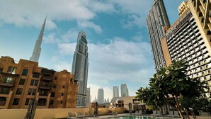 A pool area with a view of tall buildings, including a prominent tower. - New 2B | Burj Khalifa | Dubai Mall | 2 Pools | Gym (Dubai)