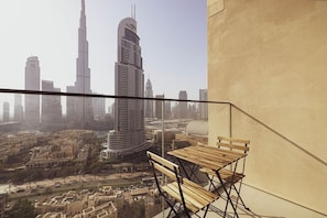 A balcony with a view of a cityscape including a prominent skyscraper.