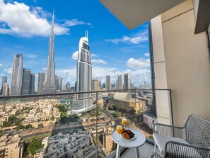 Un balcone con vista sulla città, un tavolo imbandito per la colazione e arredi moderni.