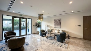 Eine moderne Lobby mit einer Couch, Sesseln, einem Couchtisch und einer Topfpflanze.