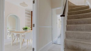 A staircase with carpeted steps and a wooden handrail, leading to a room with a white door. - Prime Location 2 Bed East London (London)