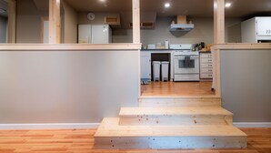 A modern kitchen with wooden beams, a refrigerator, a stove, and a sink. - Cobb Mountain Chalet King Size Suite (Cobb)