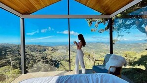 Una habitación con un ventanal grande que ofrece una vista panorámica de un paisaje montañoso.