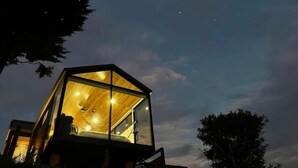 A hexagonal glass structure with a wooden interior, surrounded by trees. - Luxury Glass Cabin- 270° Ocean & Forest Views + Hot Tub (Provincia de Puntarenas)