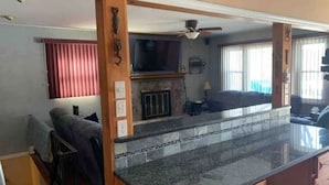A kitchen with a granite countertop, a fireplace, and a ceiling fan. - Lake Hopatcong cottage with dock; Permit #2023-6
(Hopatcong)