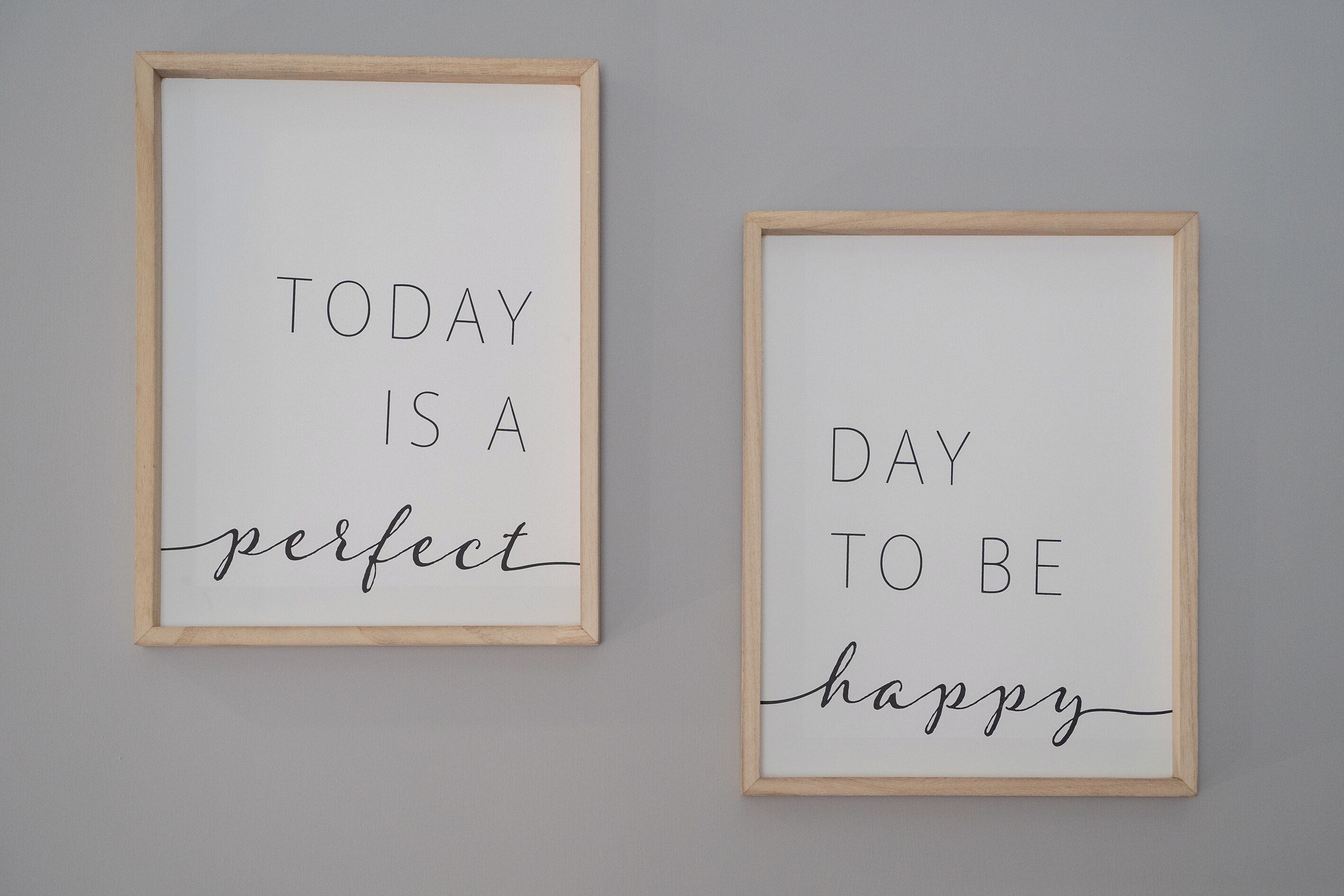 Dos frases motivacionales enmarcadas en una pared.