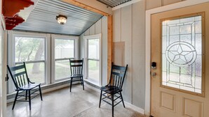 A room with three wooden chairs, a door with a stained glass window, and a ceiling fan. - Lake Brownwood Home w/ Private Boat Dock! (Brownwood)