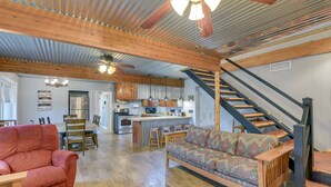 A spacious living area with a wooden ceiling, a sofa, a red armchair, and a staircase. - Lake Brownwood Home w/ Private Boat Dock! (Brownwood)