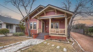 A two-story house with a front porch, a small front yard, and a visible address number.