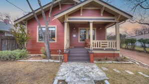 A two-story house with a front porch, a stone pathway leading to the entrance, and a small front yard.