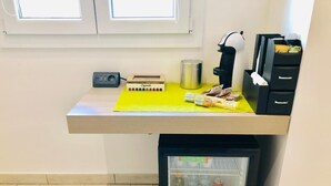 A compact kitchenette with a small refrigerator containing beverages, a coffee maker, a toaster, and a microwave. - Bardilio Luxury Rooms IUN P1813 (Cagliari)