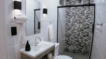 Ein modernes Badezimmer mit Waschbecken, Spiegel und Toilette in Weiß.