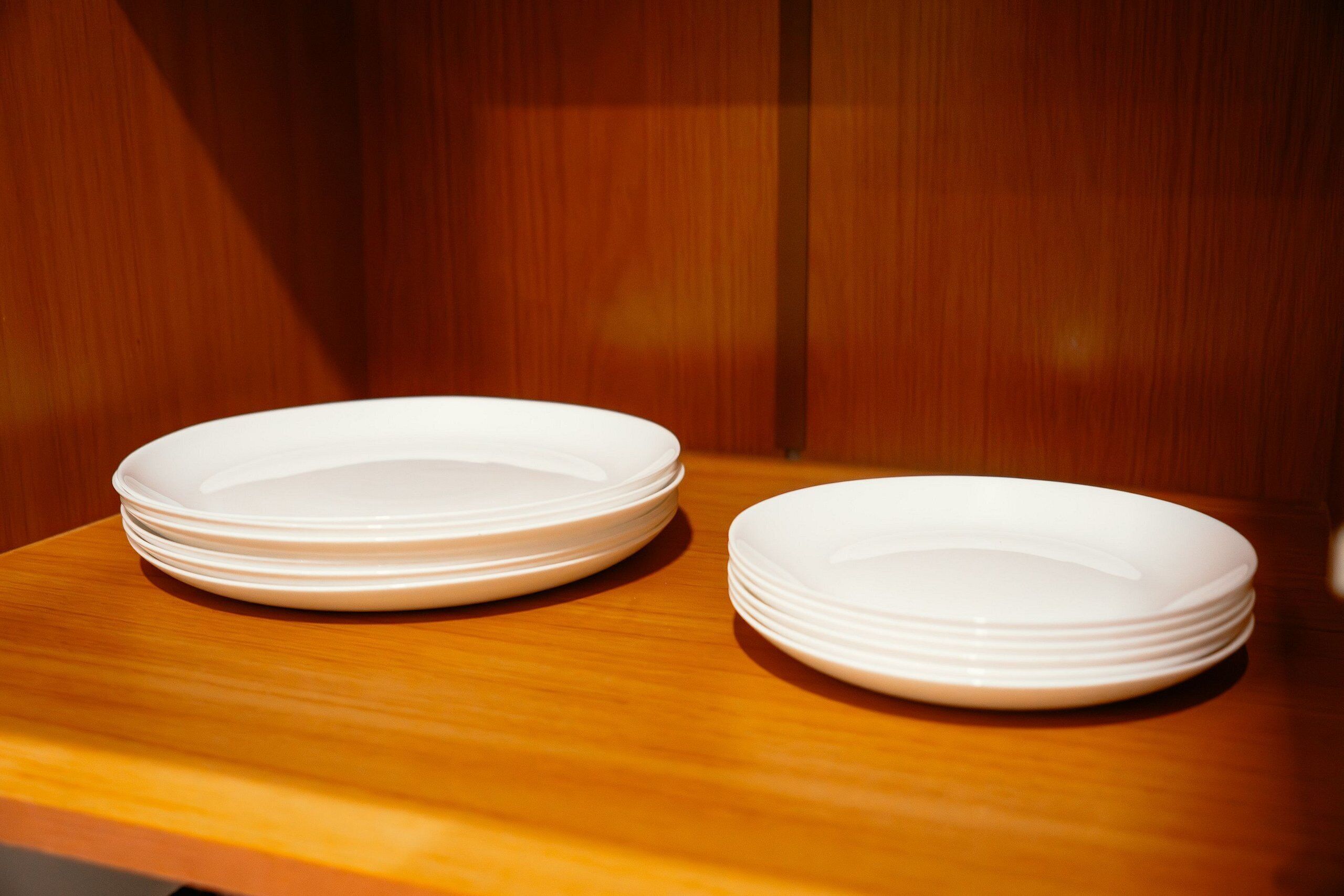 Una pila de platos blancos sobre una superficie de madera.