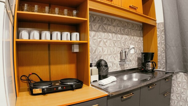Een kitchenette met een koffiezetapparaat, een waterkoker en een Duocook elektrische kookplaat.