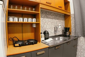 A kitchenette with a coffee maker, a kettle, and a Duocook electric stove. - VILLA BILAC 04 (Blumenau)