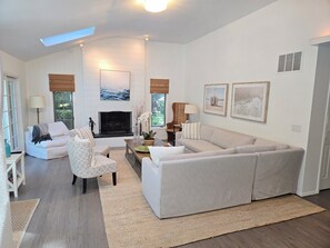 A modern living room with a fireplace, a sofa, a chair, and a coffee table. - Beautiful East Hampton Retreat (East Hampton)