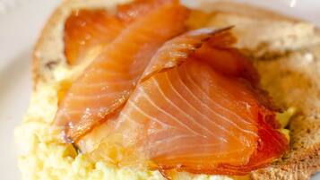 Un piatto con uova strapazzate e salmone affumicato su pane tostato.