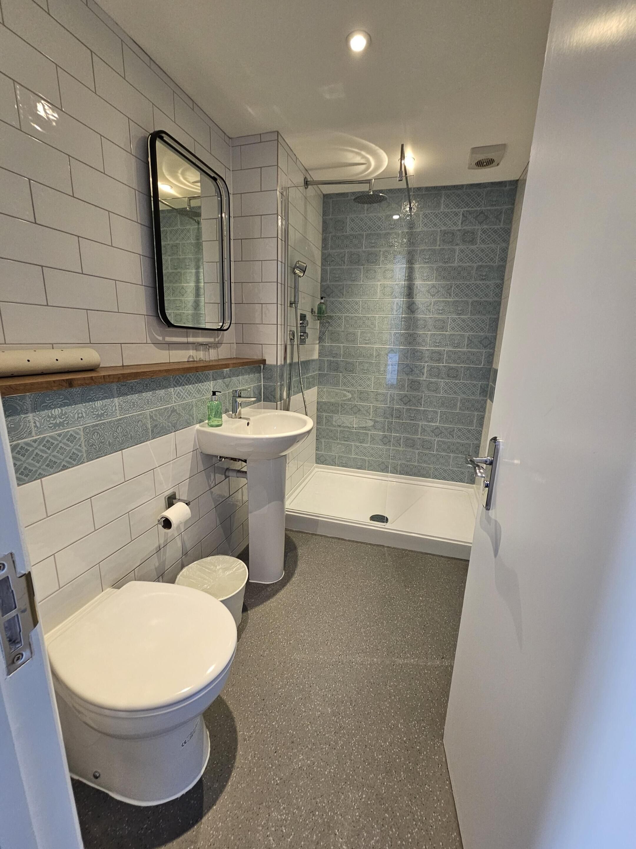 A bathroom with a toilet, sink, and shower.