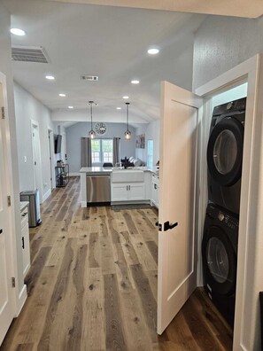 A modern kitchen with white cabinets, a stainless steel refrigerator, and a central island.