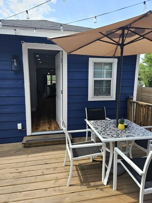 A blue house with a deck, a table with chairs, and a large umbrella. - ~ Houston Heights 4-plex with patio ~ (Houston)
