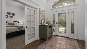 A bedroom with a bed, a dresser, and a mirror. There is a door leading to a balcony. - Luxury - 6000sqft- Sleeps 22+ Basketball, Billiards, Theater, Game, PrincessRoom (Layton)