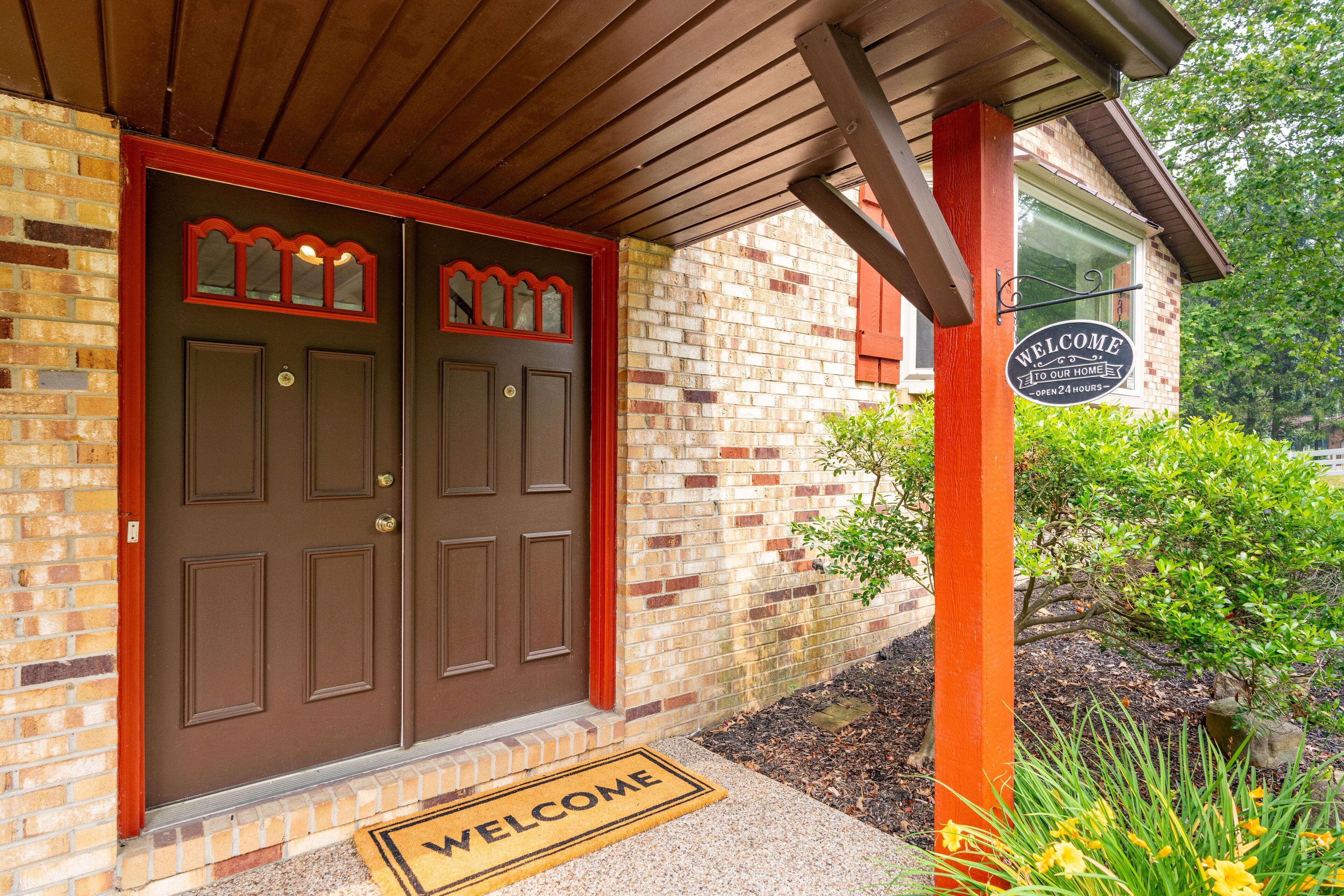 A brick building with a brown double door and a welcome sign.