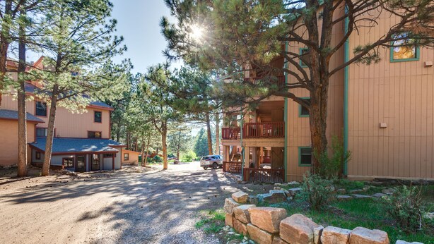A residential area with a dirt road, houses with balconies, and surrounding trees. - Angel Fire Studio w/ Fireplace, Walk to Resort! (Angel Fire)