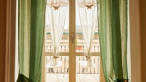 Una habitación con vista a un balcón con sillas y mesas.