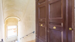 Un escalier avec une rampe menant à une porte marron ornée de deux poignées dorées.