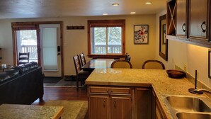 A kitchen with granite countertops, wooden cabinets, and a stainless steel sink.