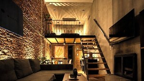 A modern living room with a sofa, coffee table, and a staircase leading to an upper level. - TinyChillHouse (Mineral del Monte)