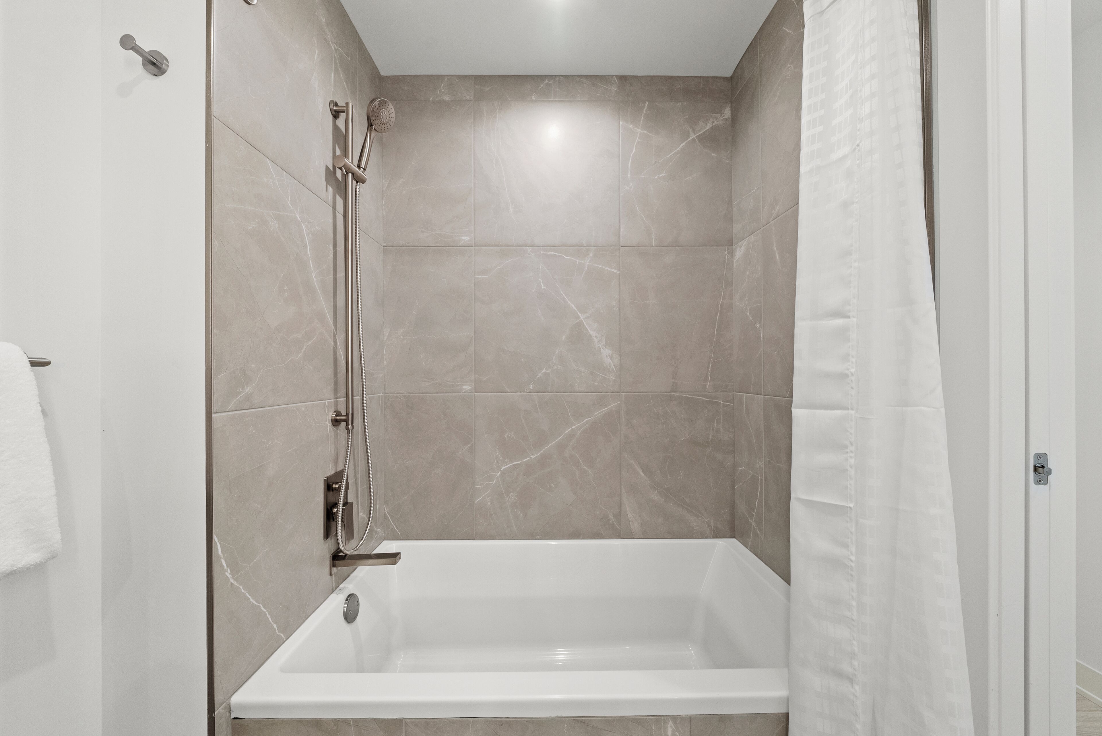 A modern bathroom with a walk-in shower, a bathtub, and a toilet.