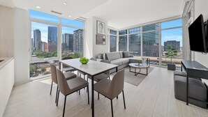 A modern living room with a dining area, large windows, and a city view. - Level Chicago Fulton Market (Chicago)