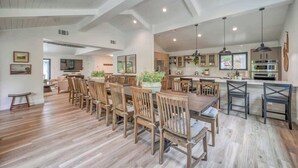 Une cuisine spacieuse avec des meubles en bois, un îlot central et des luminaires suspendus.