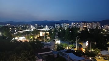Un paisaje urbano al anochecer con un puente destacado, edificios residenciales y zonas comerciales.