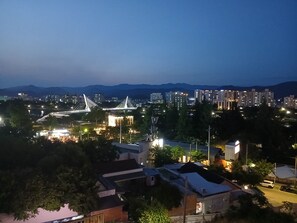 A cityscape at dusk with a prominent bridge, residential buildings, and a mix of commercial areas. - LOL Motel (Daegu)