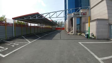 Un estacionamiento con espacios demarcados, una pasarela techada y un edificio con un letrero que dice 'Motel'.