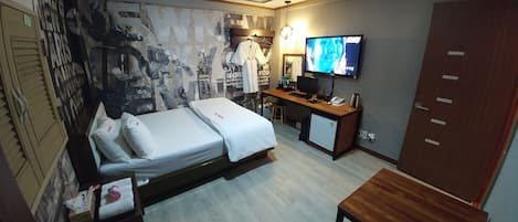 Une chambre d’hôtel équipée d’un lit, d’un bureau, d’une télévision et d’une armoire.